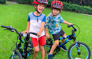 Two boys riding their Guardian Black Blue Green and Black Blue Bikes
