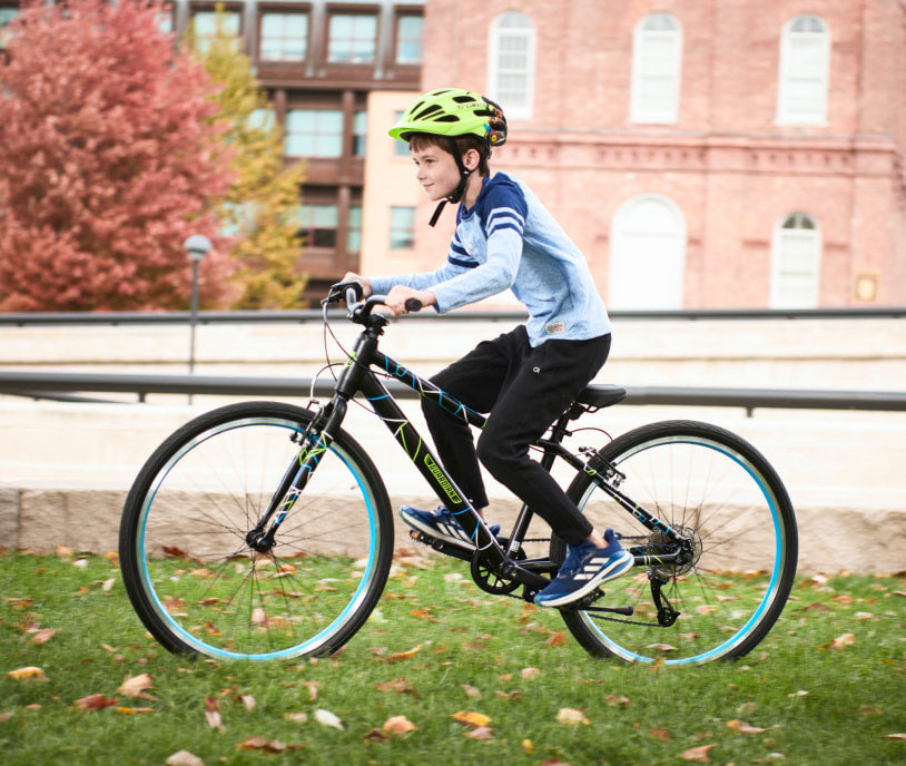 A boy riding a bike through a city park